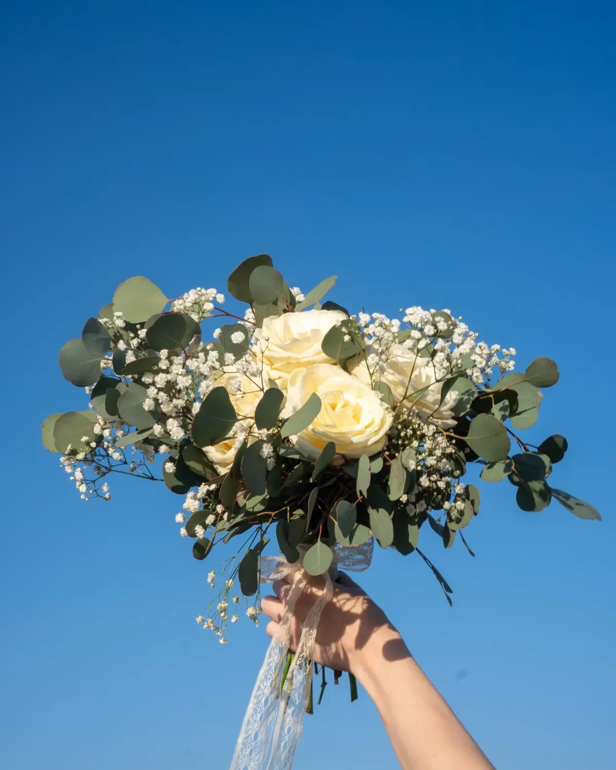 Amara egyszerű fehér menyasszonyi csokor kézben