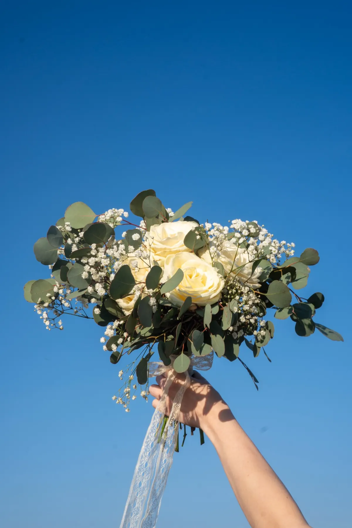 Amara egyszerű fehér menyasszonyi csokor kézben